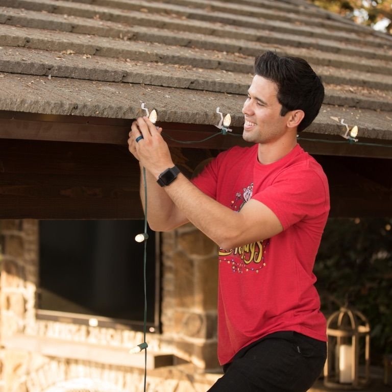 A Light Guys crew member installing roofline lights